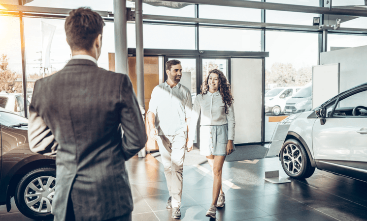 Couple walking into car dealership