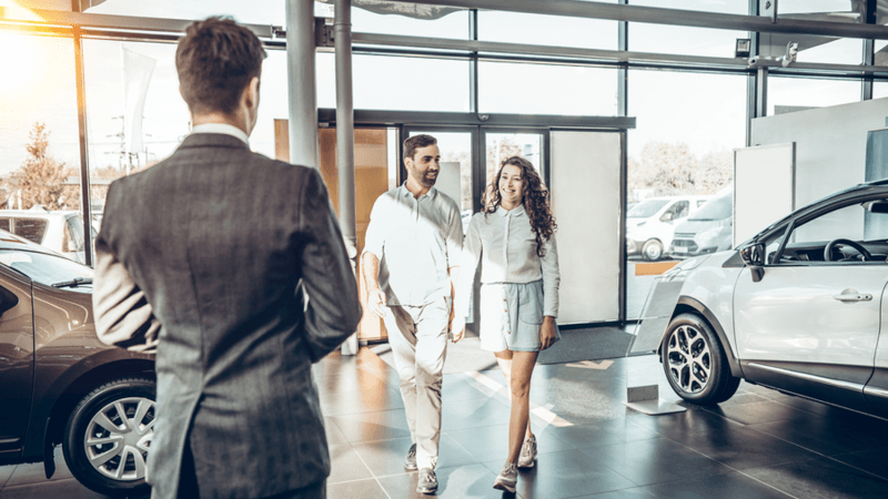 Couple walking into car dealership