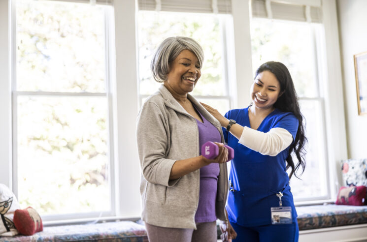 Nurse supporting woman lifting weight