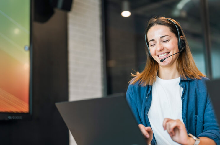 Woman with headset on laptop