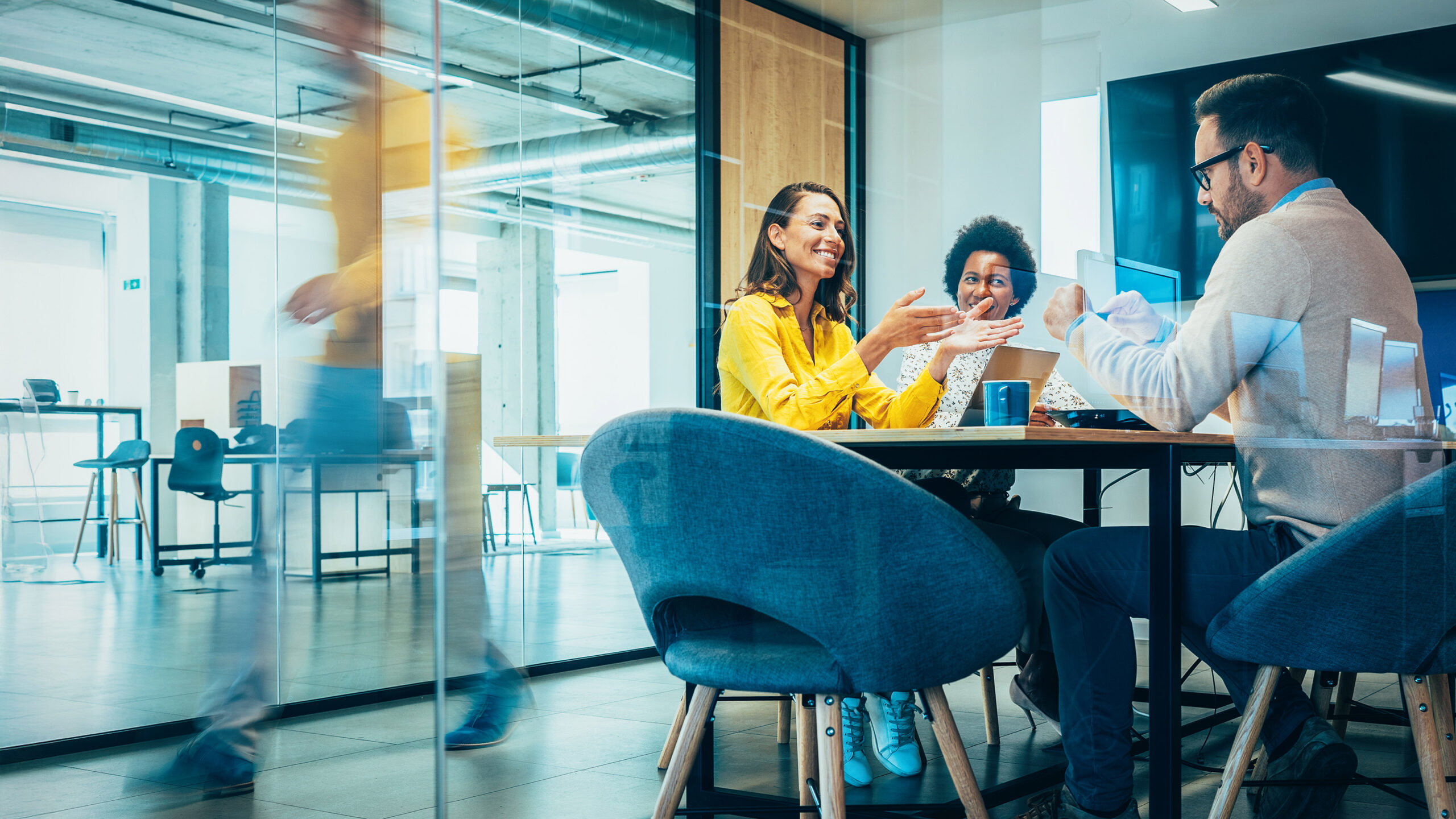 Man and two women sitting in conference room