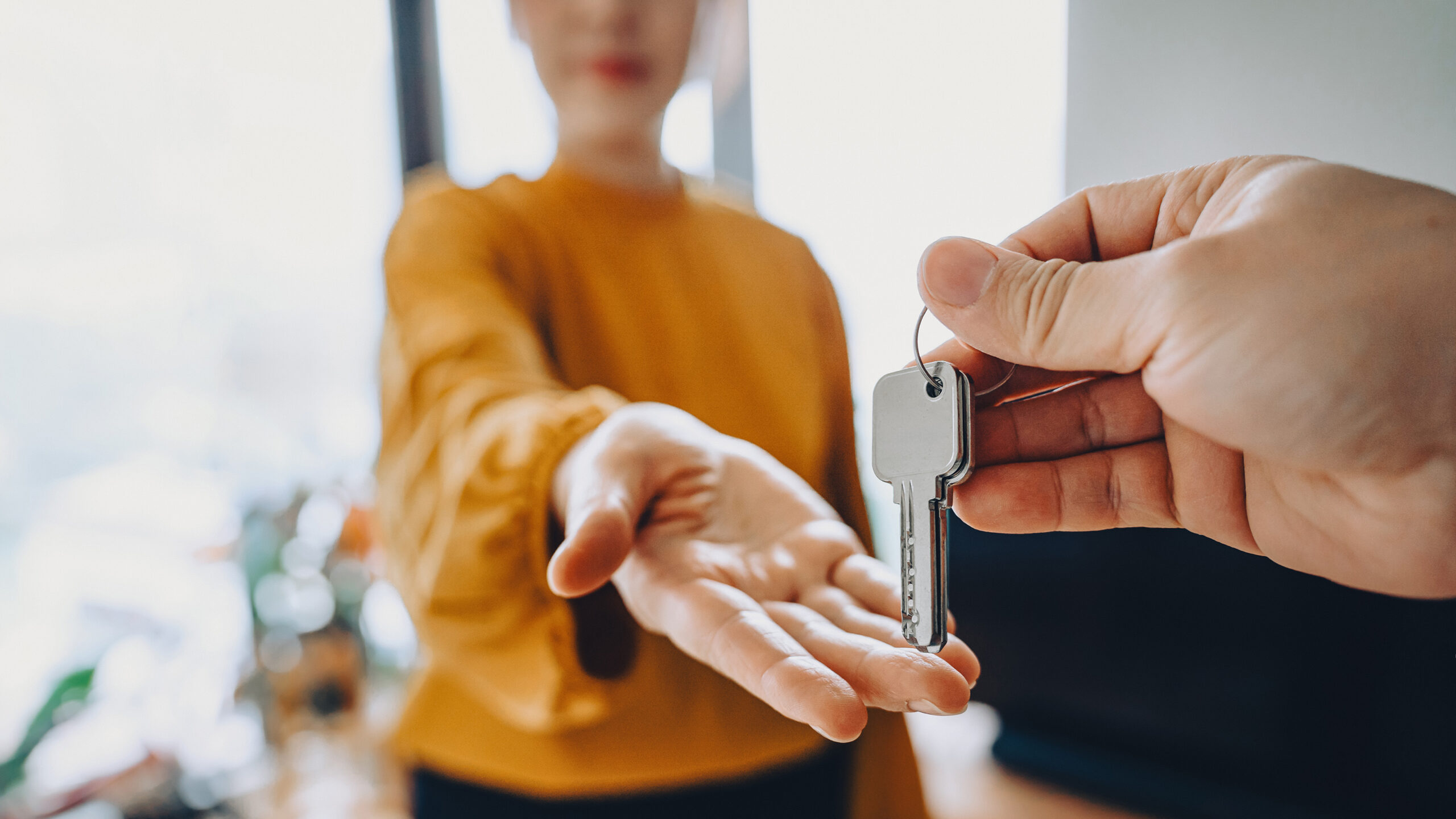 Woman being handed a set of door keys