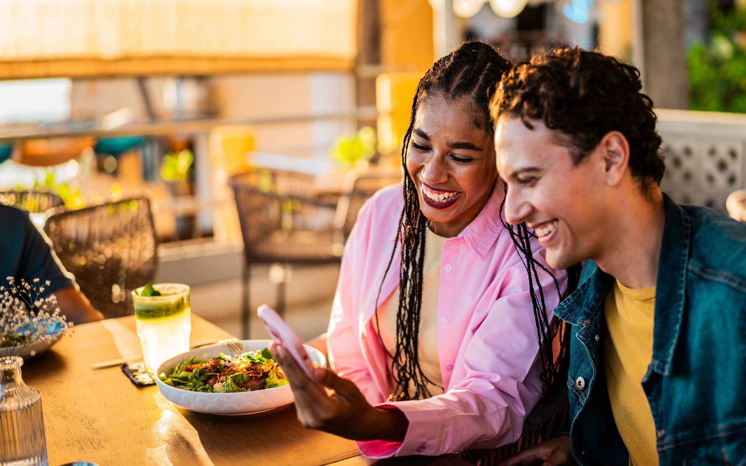 Happy woman and man leaving review on phone in a restaurant